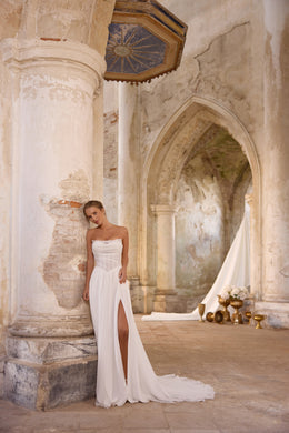 Ivory strapless A-line wedding dress with a ruched bodice, thigh-high slit, and sweeping train