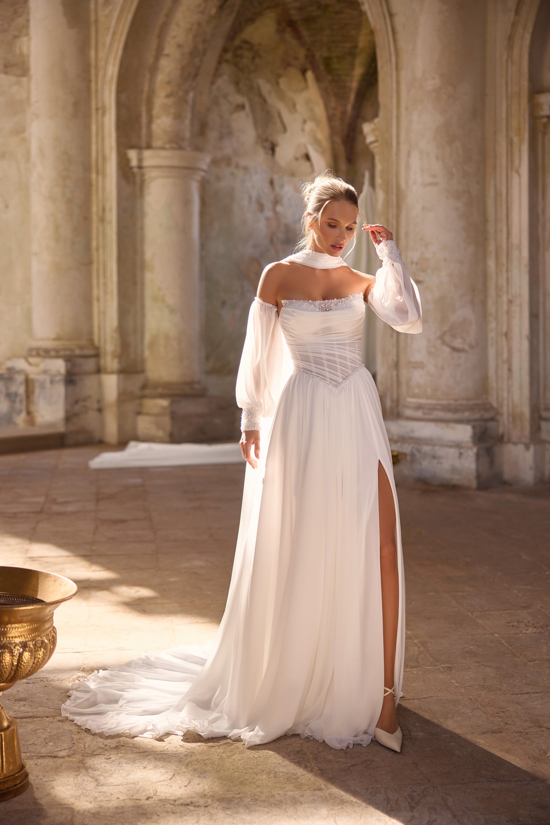 Ivory wedding dress with sheer off-the-shoulder sleeves, embellished bodice, high slit, and long train