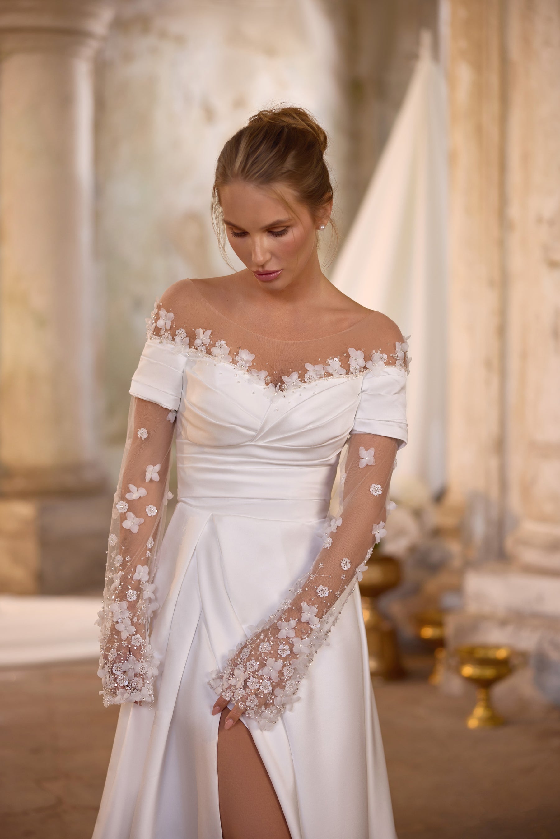 Ivory wedding dress with a draped neckline, detachable sheer floral-lace sleeves, and a front slit