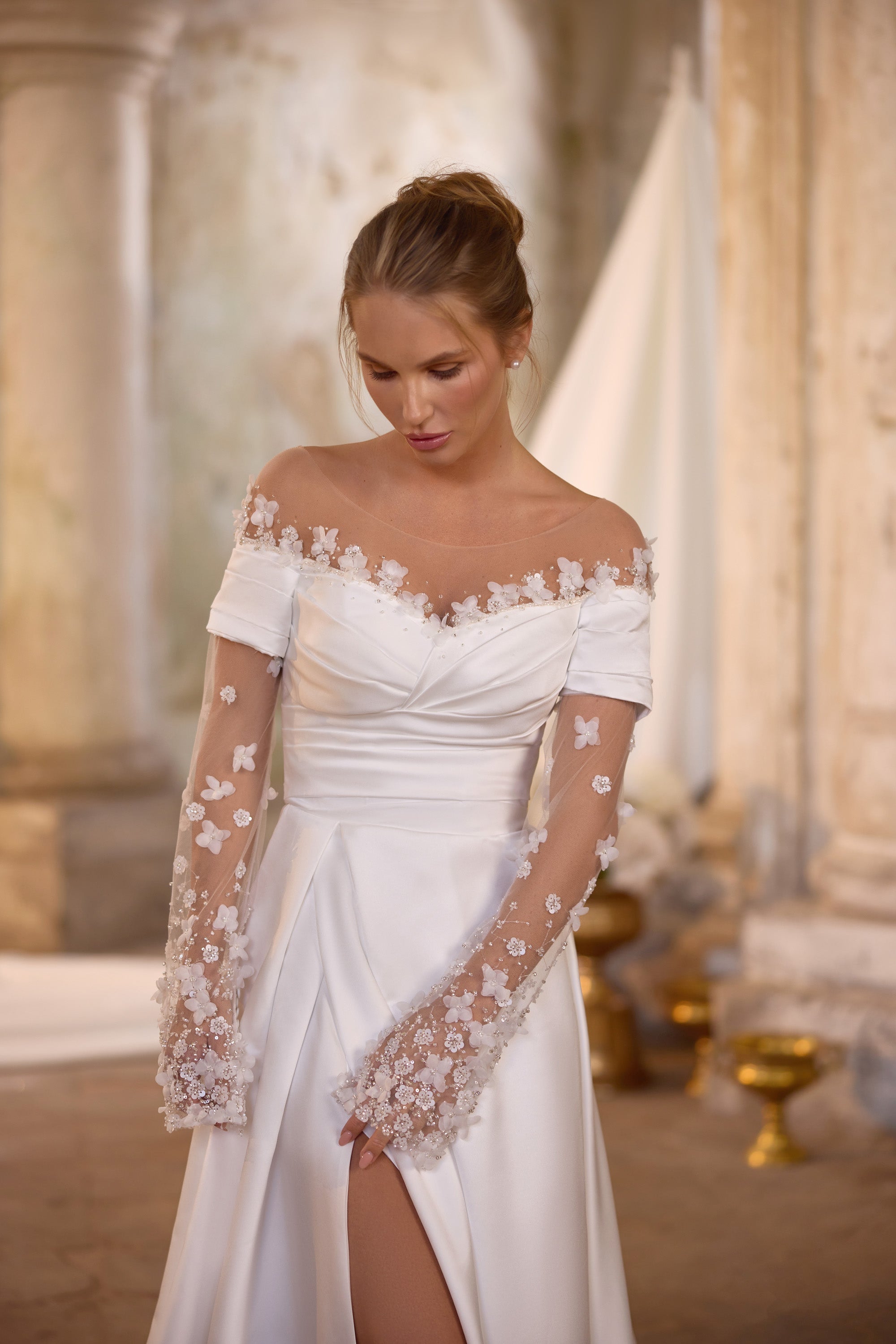 Ivory wedding dress with a draped neckline, detachable sheer floral-lace sleeves, and a front slit