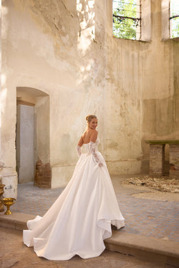 Lace-up back and sweeping train on an ivory ball gown wedding dress with long lace sleeves