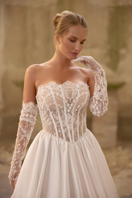 Close-up of floral lace corset and sweetheart neckline on an ivory wedding dress with sheer lace sleeves