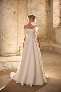 Ivory A-line wedding dress with an off-the-shoulder neckline, short sleeves, lace appliqués, and a train