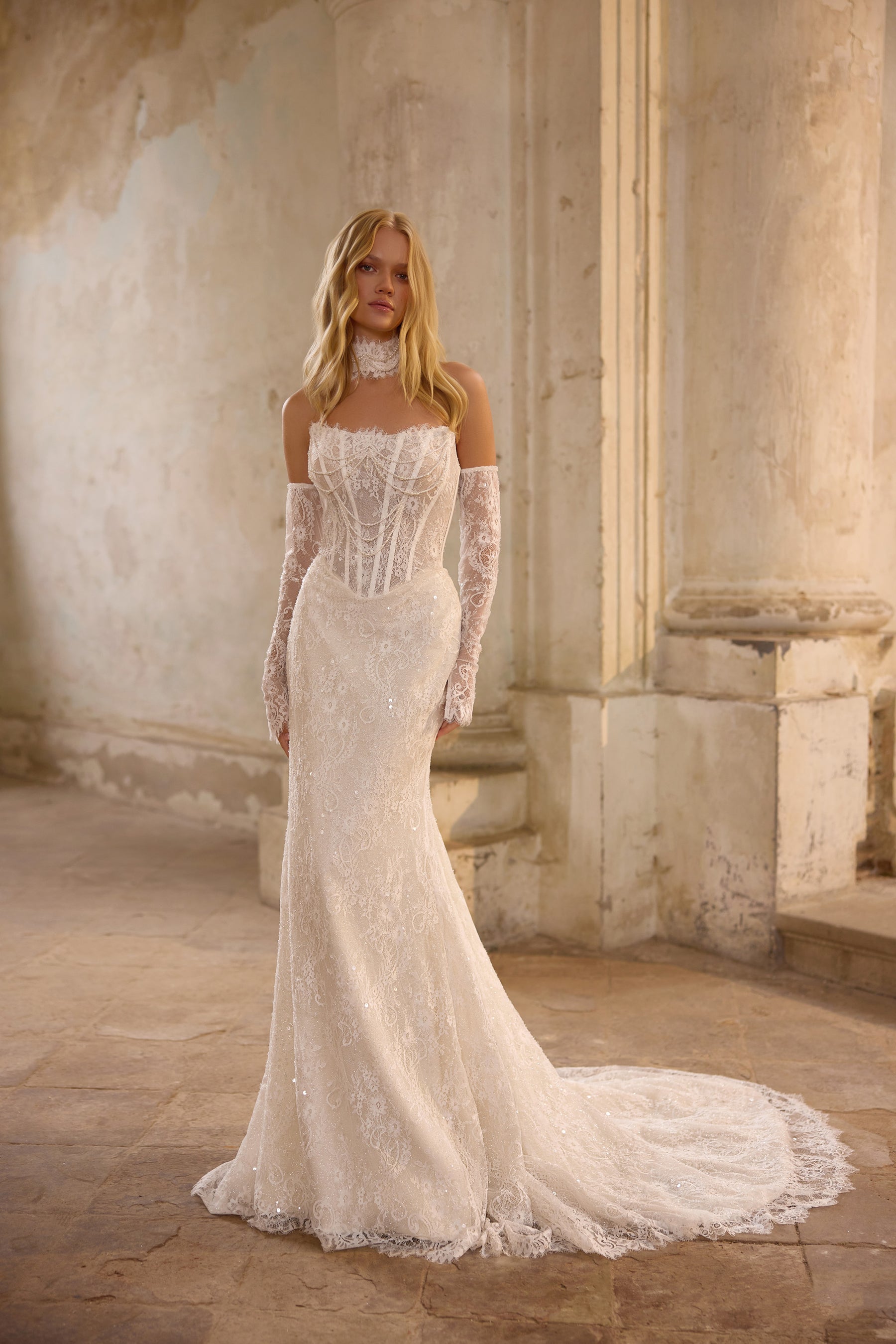 Ivory mermaid wedding dress with a beaded corset, lace off-the-shoulder sleeves, and sweeping train