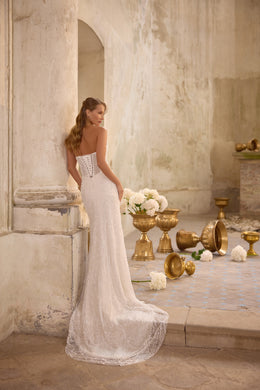 Beaded mermaid wedding dress with a corset-laced back, slim straps, and a sweeping train