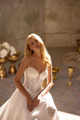 Ivory wedding dress with a strapless sweetheart bodice, lace corset panels, and full skirt