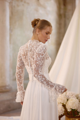 Ivory wedding dress with a sheer lace back, long floral lace sleeves, and covered buttons