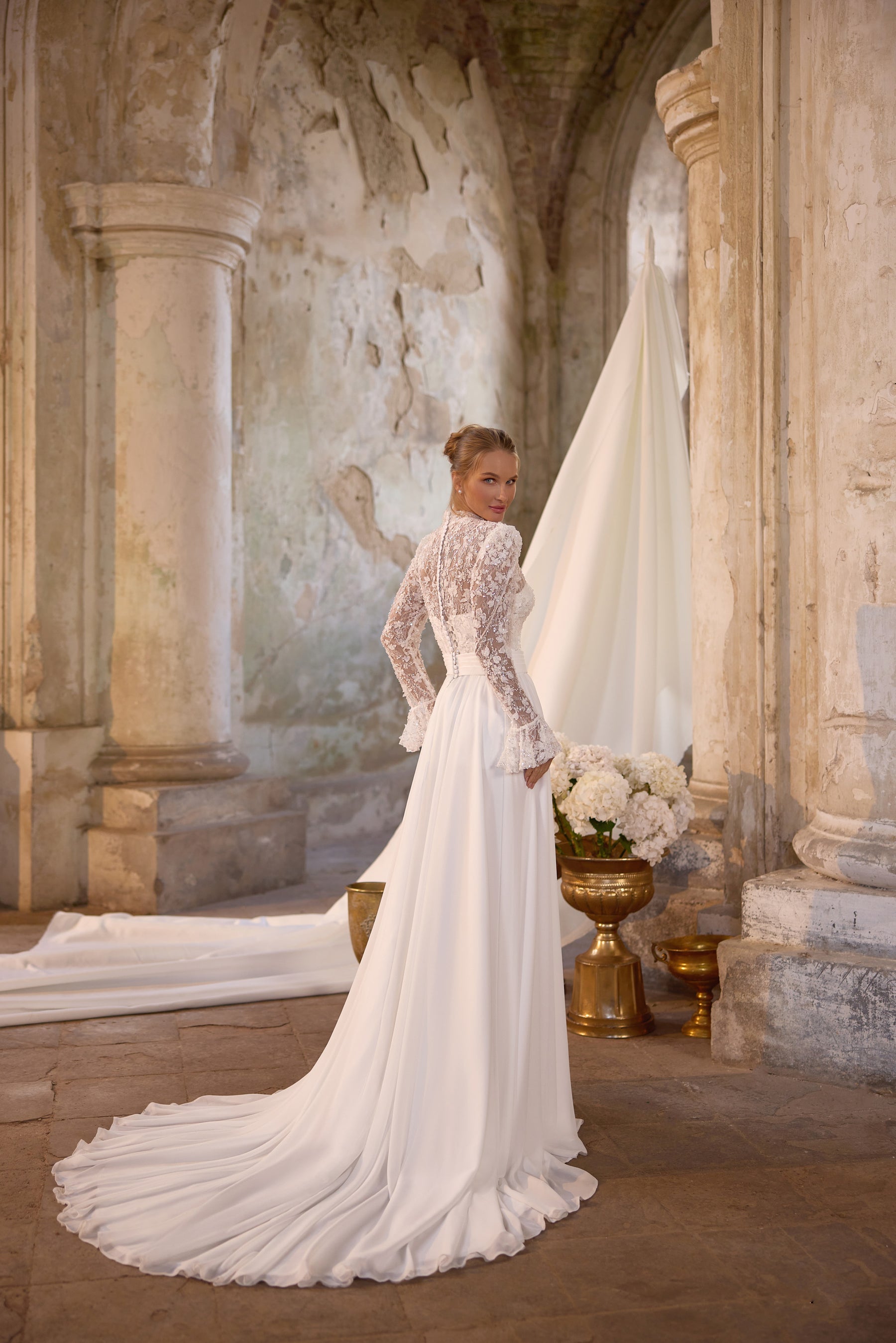 Ivory wedding dress with a fitted lace bodice, long sleeves, and a sweeping floor-length train