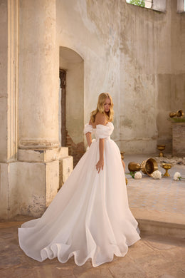 White A-line wedding dress with an off-the-shoulder neckline, puff sleeves, and a sweeping train