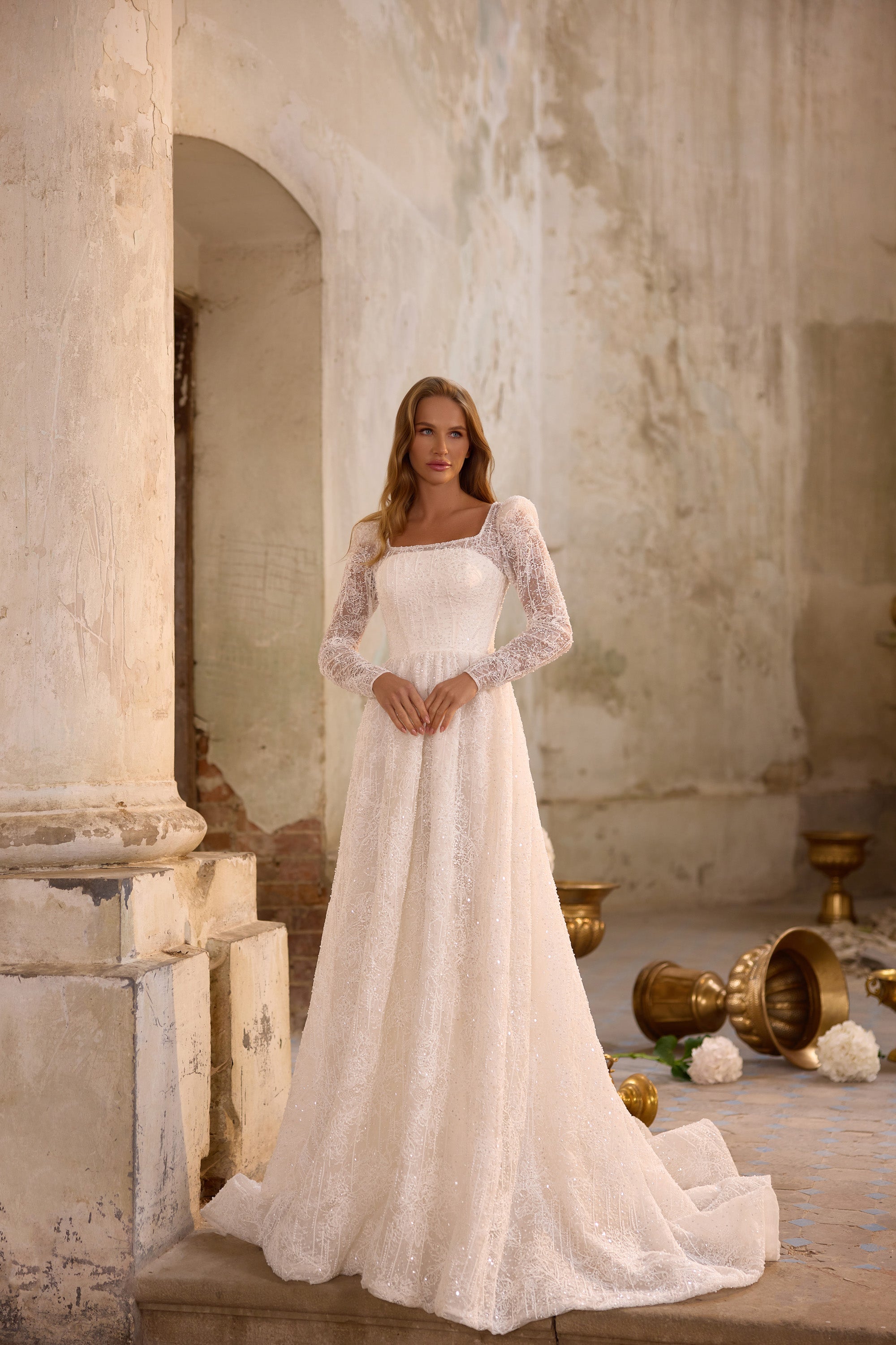 Ivory A-line wedding dress featuring a square neckline, sheer floral lace sleeves, and a full trailing skirt