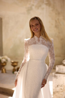 Ivory wedding dress featuring a high illusion neckline, sheer lace sleeves, and a fitted beaded bodice