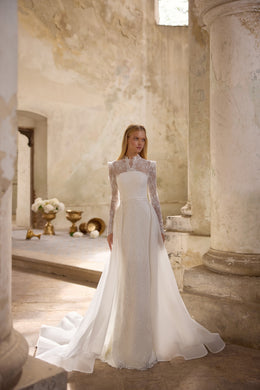 Ivory wedding dress with a fitted beaded gown and flowing overskirt extending into a long train