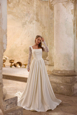 Ivory wedding dress featuring a square neckline, fitted bodice, long lace sleeves, and a sweeping train