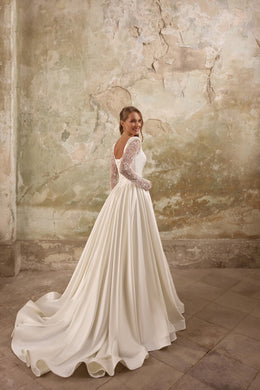 Long-train ivory wedding dress with sheer lace sleeves and a low open back, shown from behind