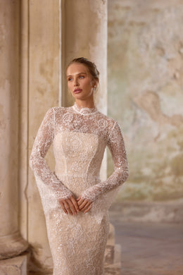 Close-up of the fitted lace bodice on an ivory wedding dress, featuring a high neckline and sheer long sleeves