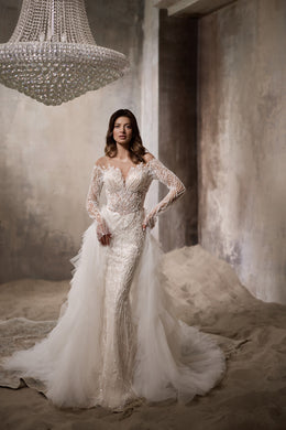 Ivory wedding dress with a beaded lace bodice, long sleeves, fitted silhouette, and tulle overskirt