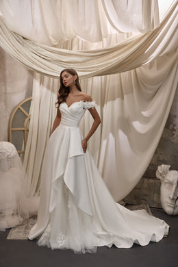 Ivory A-line wedding dress with a sweetheart neckline, ruched bodice, floral appliqués, and layered train