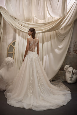 Sheer illusion back with sweeping beadwork and a long train on an ivory wedding dress