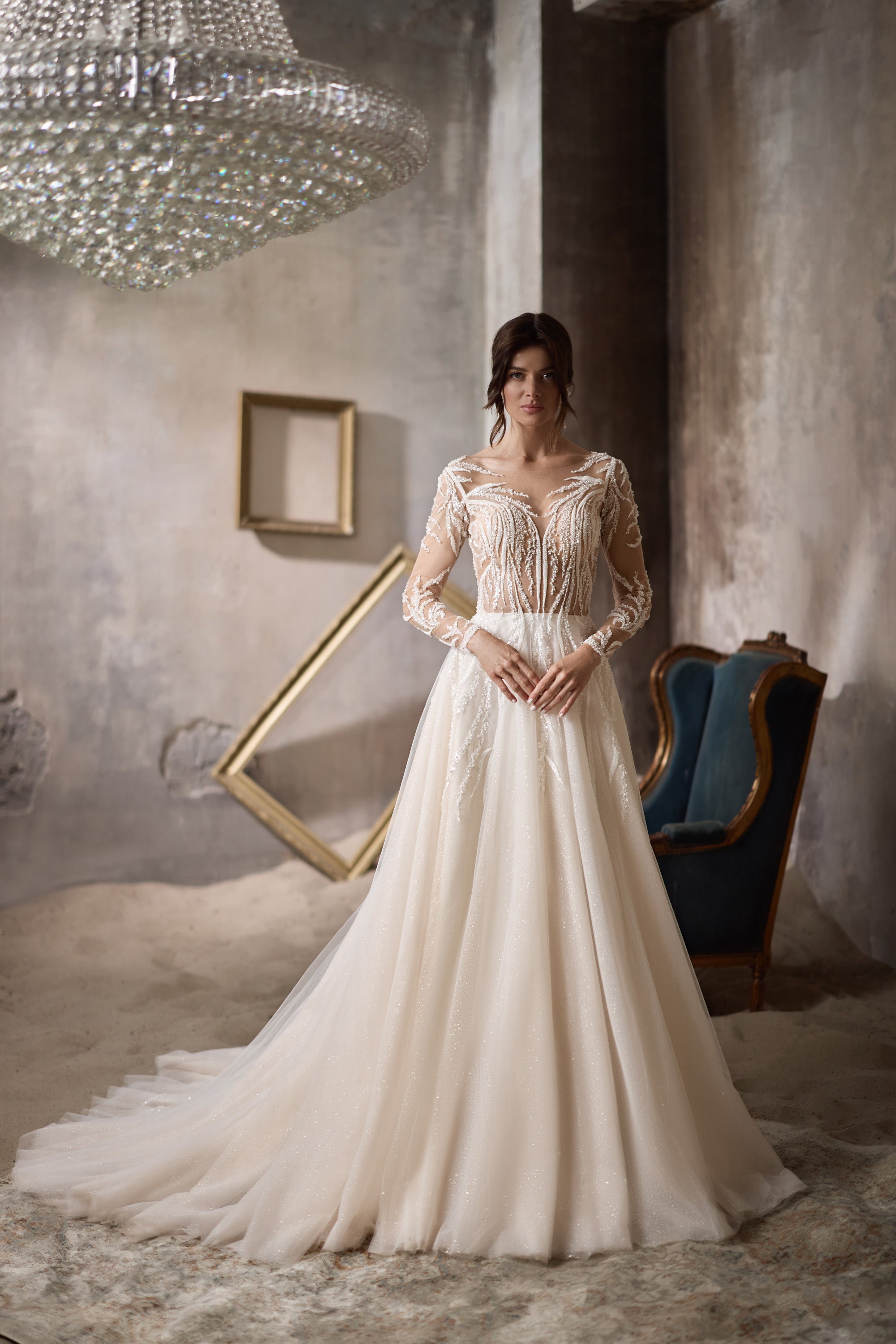 Ivory A-line wedding dress with a sheer neckline, beaded bodice, and long sleeves