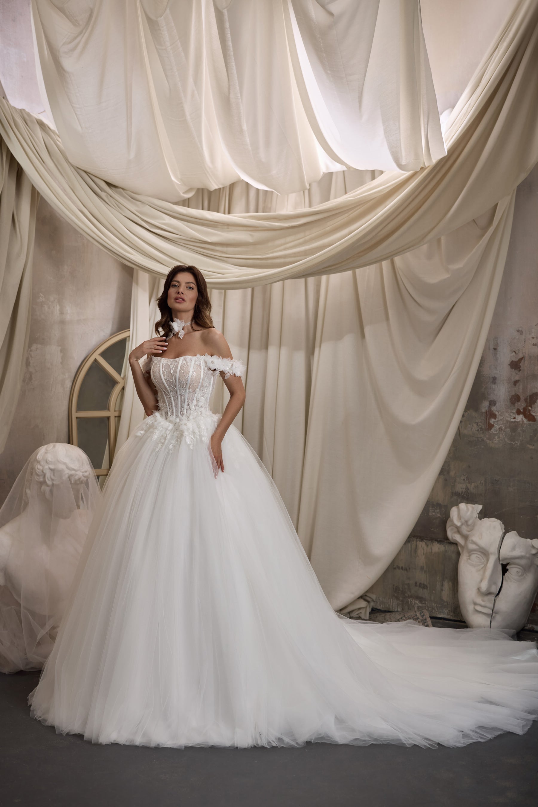 White ball gown wedding dress with an off-shoulder neckline, embellished bodice, and sweeping train