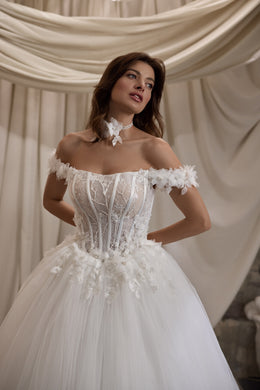 Close-up of a wedding dress with floral off-shoulder appliqués, structured bodice, and sparkling details