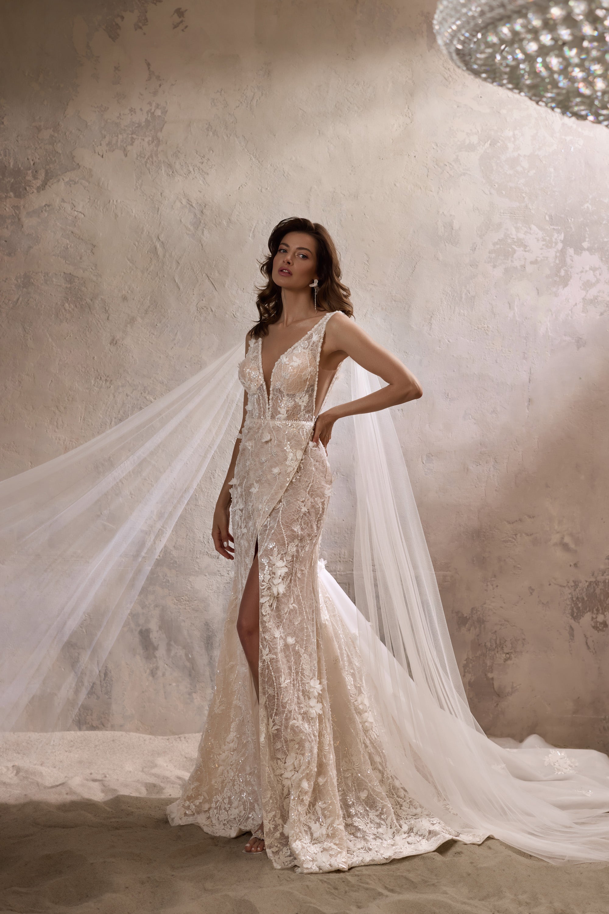 Floral lace wedding dress with a plunging V-neckline, thigh-high slit, and flowing detachable cape