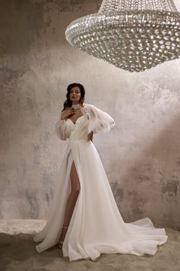 Ivory wedding dress with sheer puff sleeves, a thigh-high slit, and a long flowing train