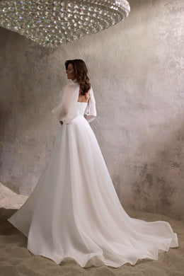 Back view of an ivory wedding dress with a low back, flowing A-line skirt, and sweeping train
