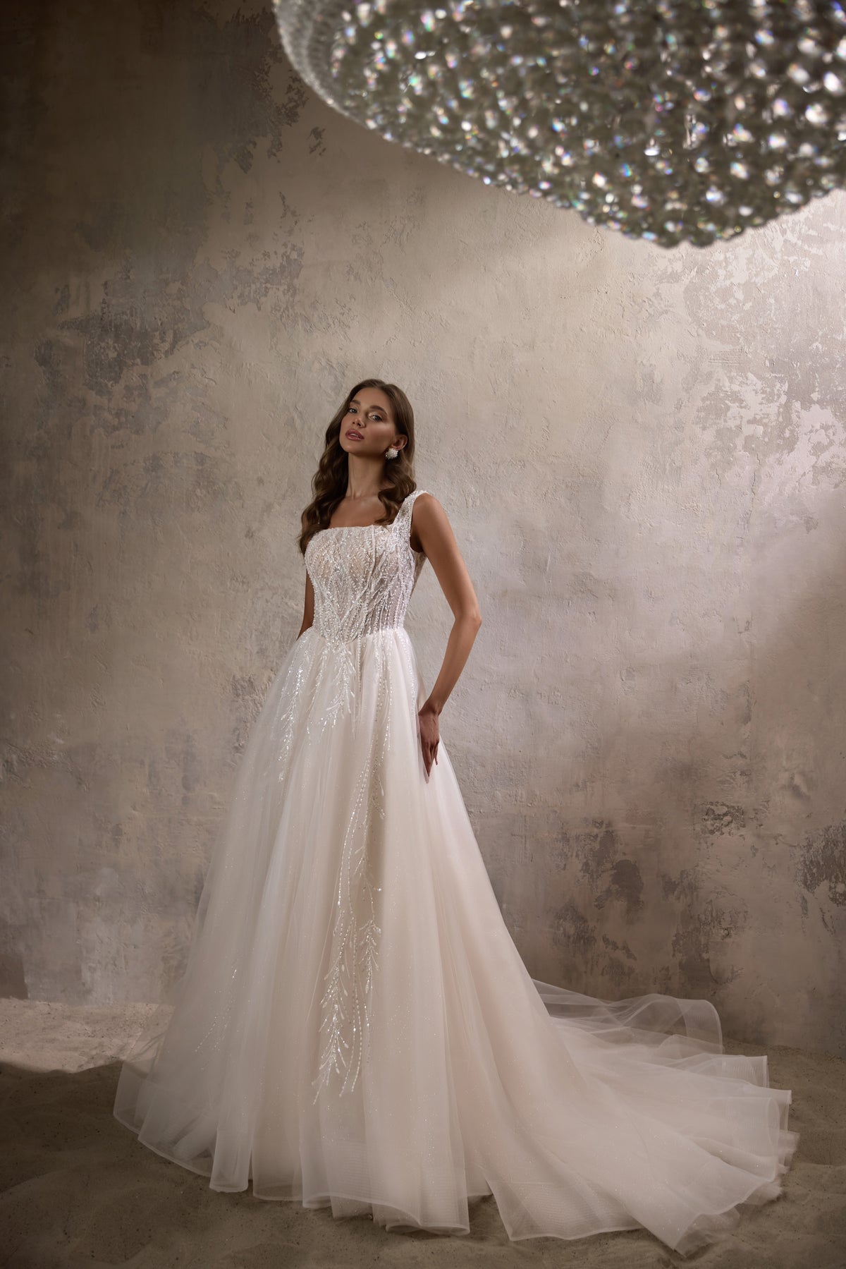 Sparkling beaded bodice and square neckline on an ivory A-line wedding dress with a long train