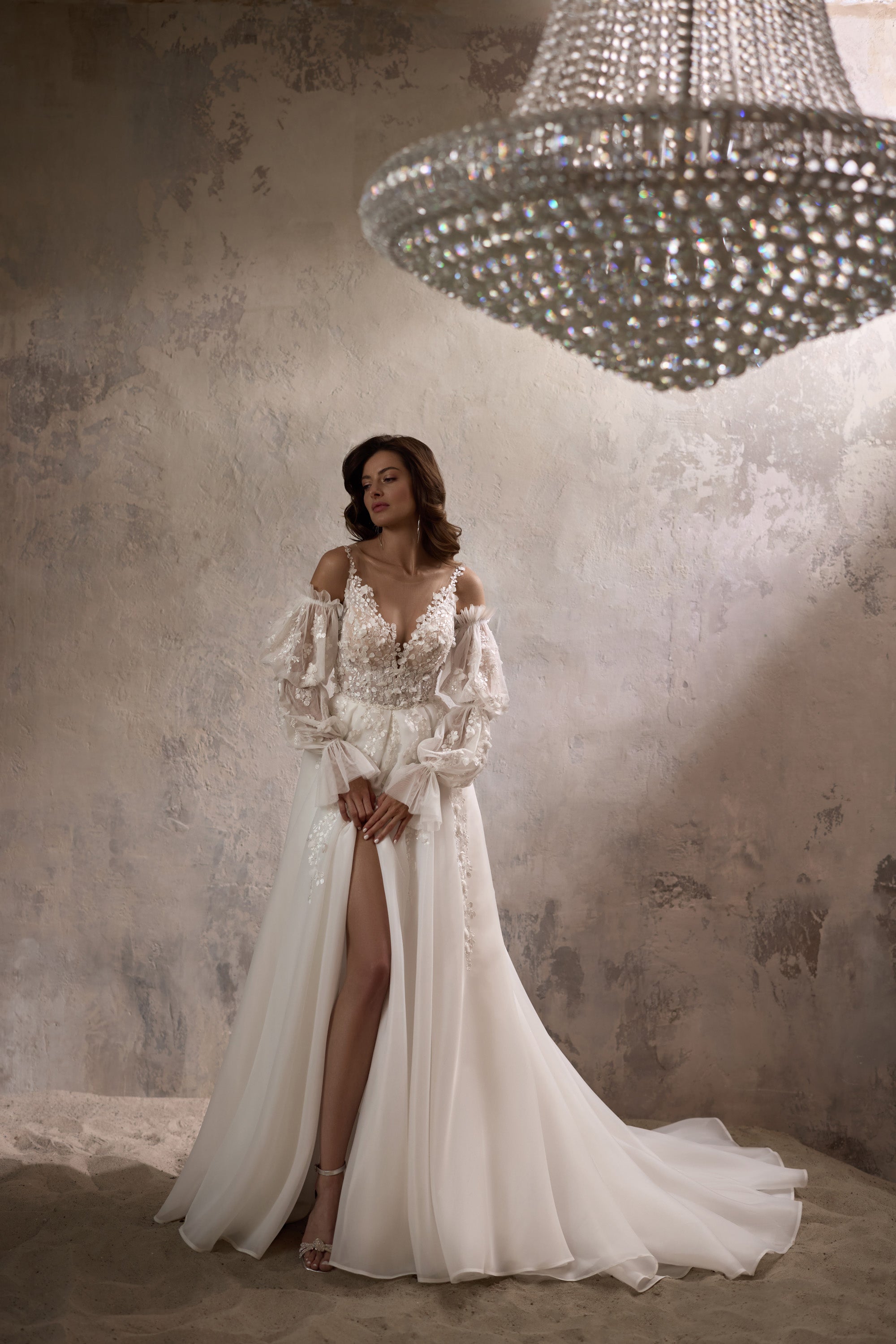 Ivory A-line wedding dress with floral lace bodice, plunging V-neckline, sheer sleeves, and front slit