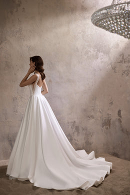 Open V-back wedding dress with beaded shoulder straps and a long flowing train