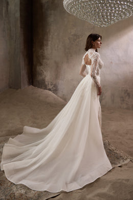 Ivory wedding dress shown from the back with a sweeping detachable overskirt and long train