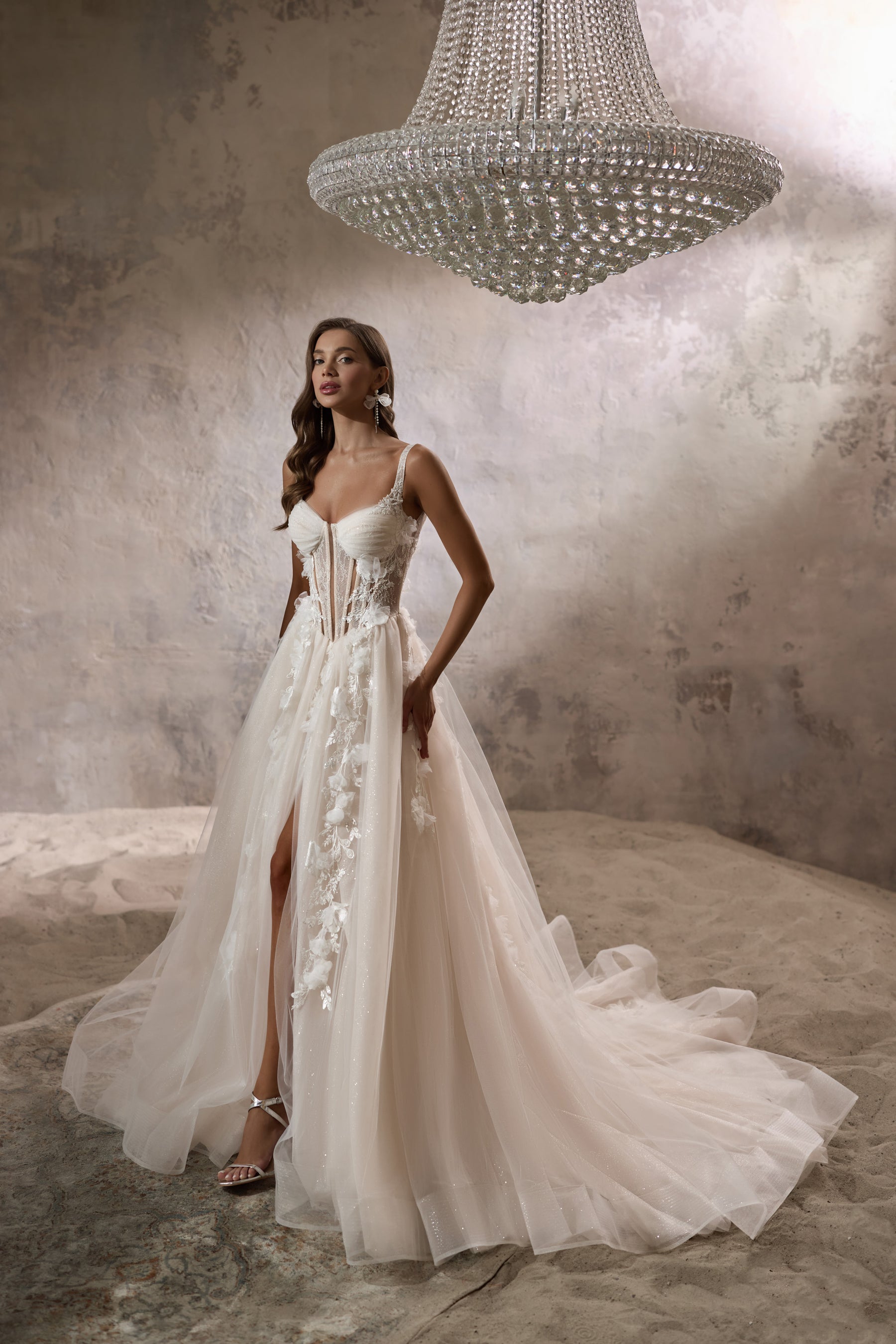 Ivory A-line wedding dress with thin straps, floral appliqués, a front slit, and a long train