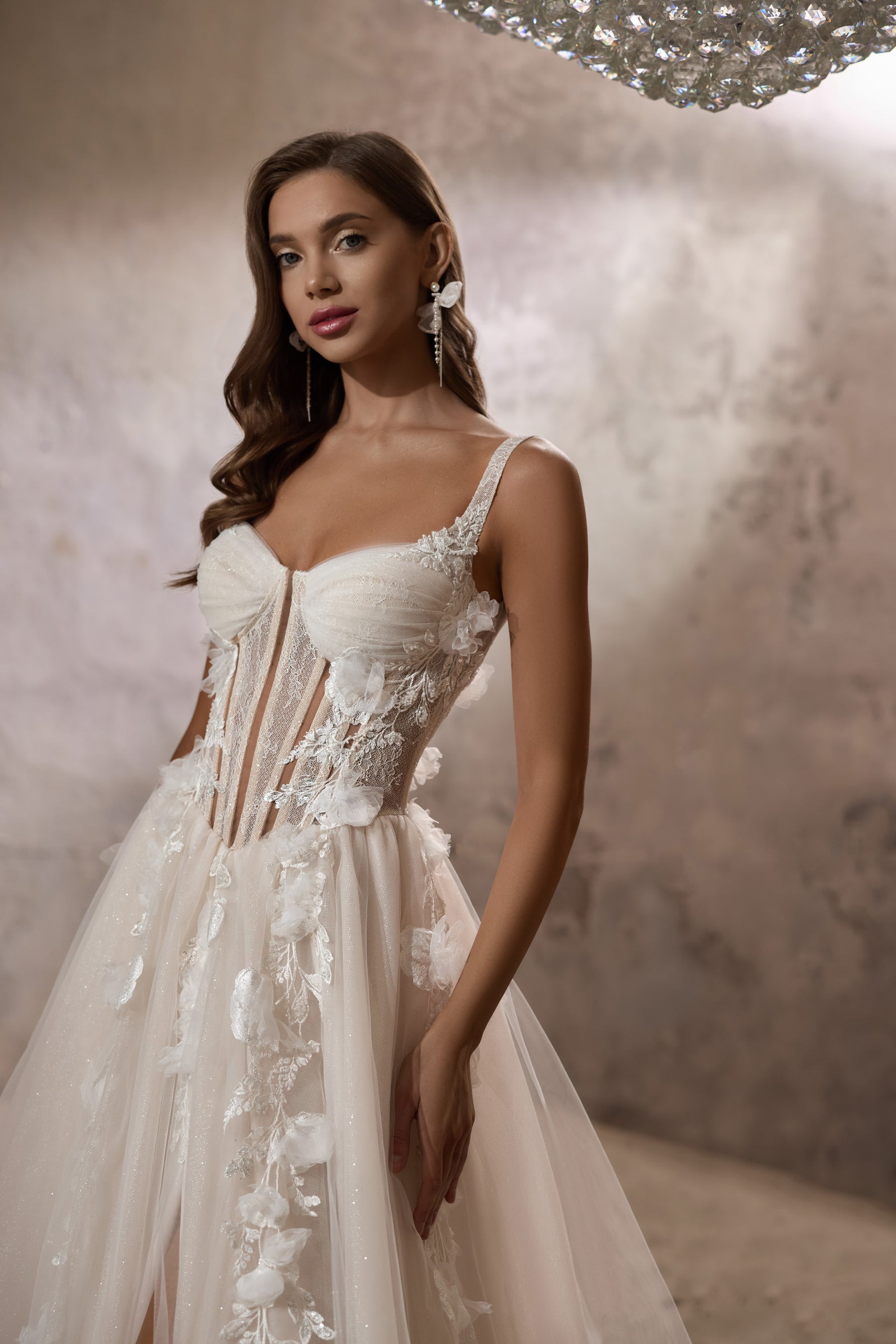 Close-up of an ivory wedding dress bodice with a sweetheart neckline, beaded lace, and floral appliqués