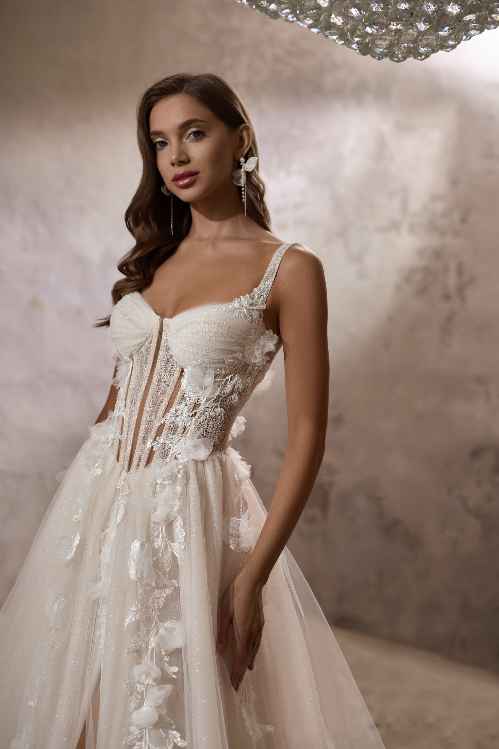 Close-up of an ivory wedding dress bodice with a sweetheart neckline, beaded lace, and floral appliqués
