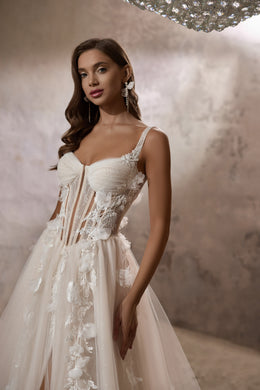 Close-up of an ivory wedding dress bodice with a sweetheart neckline, beaded lace, and floral appliqués
