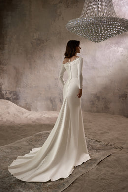 Ivory wedding dress with a lace-trimmed open back, long sleeves, fitted silhouette, and sweeping train