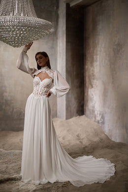 Ivory wedding dress with a lace bolero, long sheer sleeves, and a dramatic flowing train