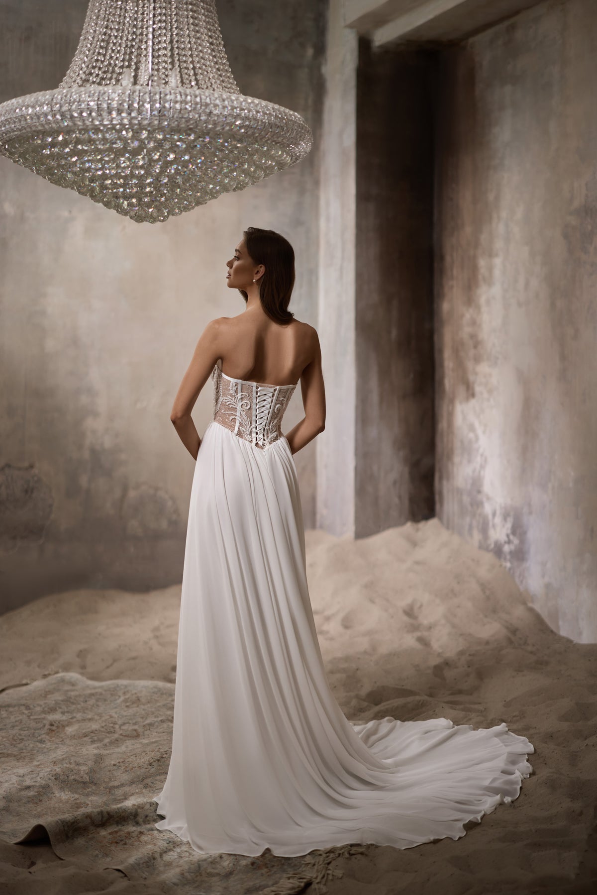Strapless ivory wedding dress with a lace-up corset back and long sweeping train