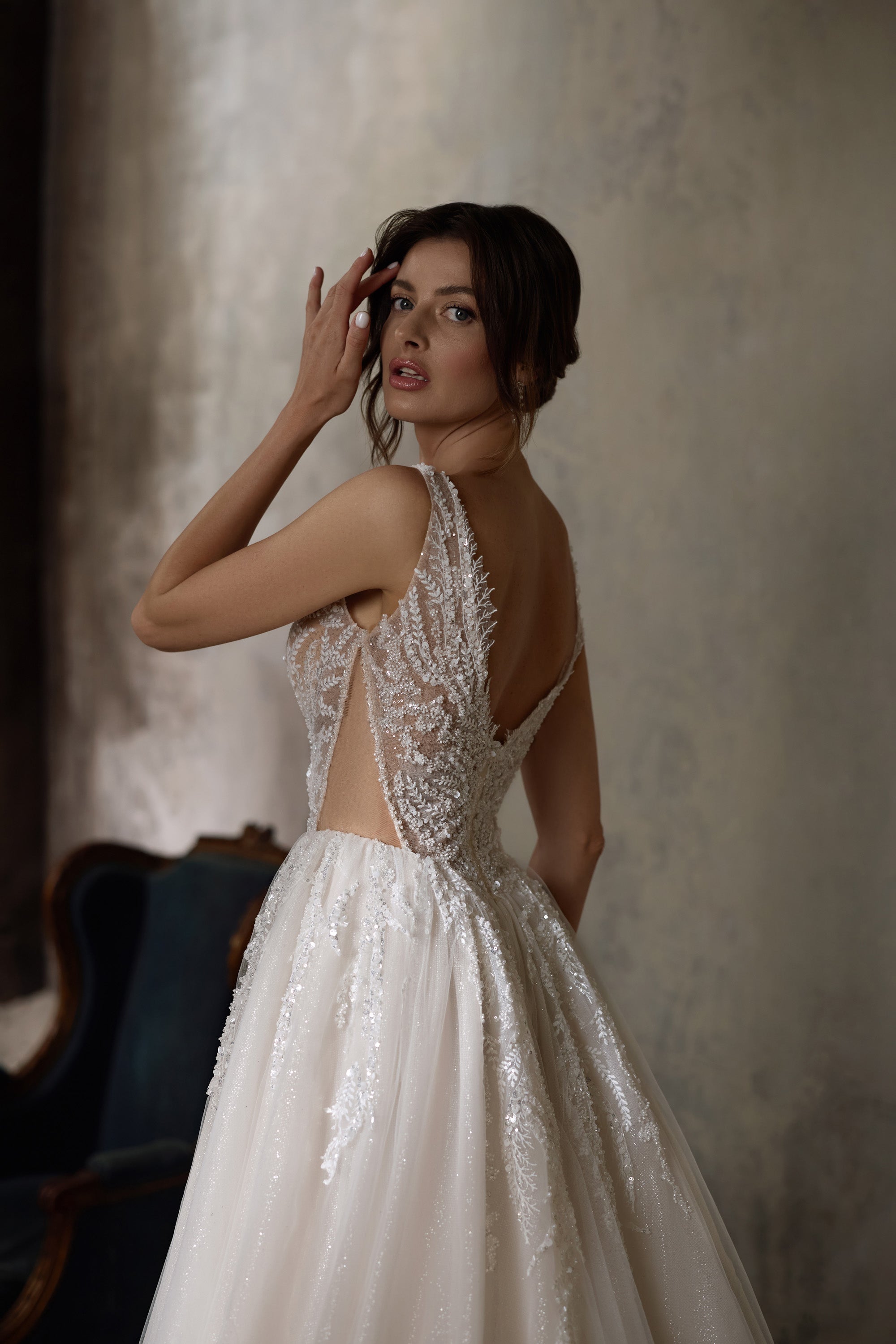 Wedding dress with a low open back, beaded lace side panels, and a softly gathered A-line skirt