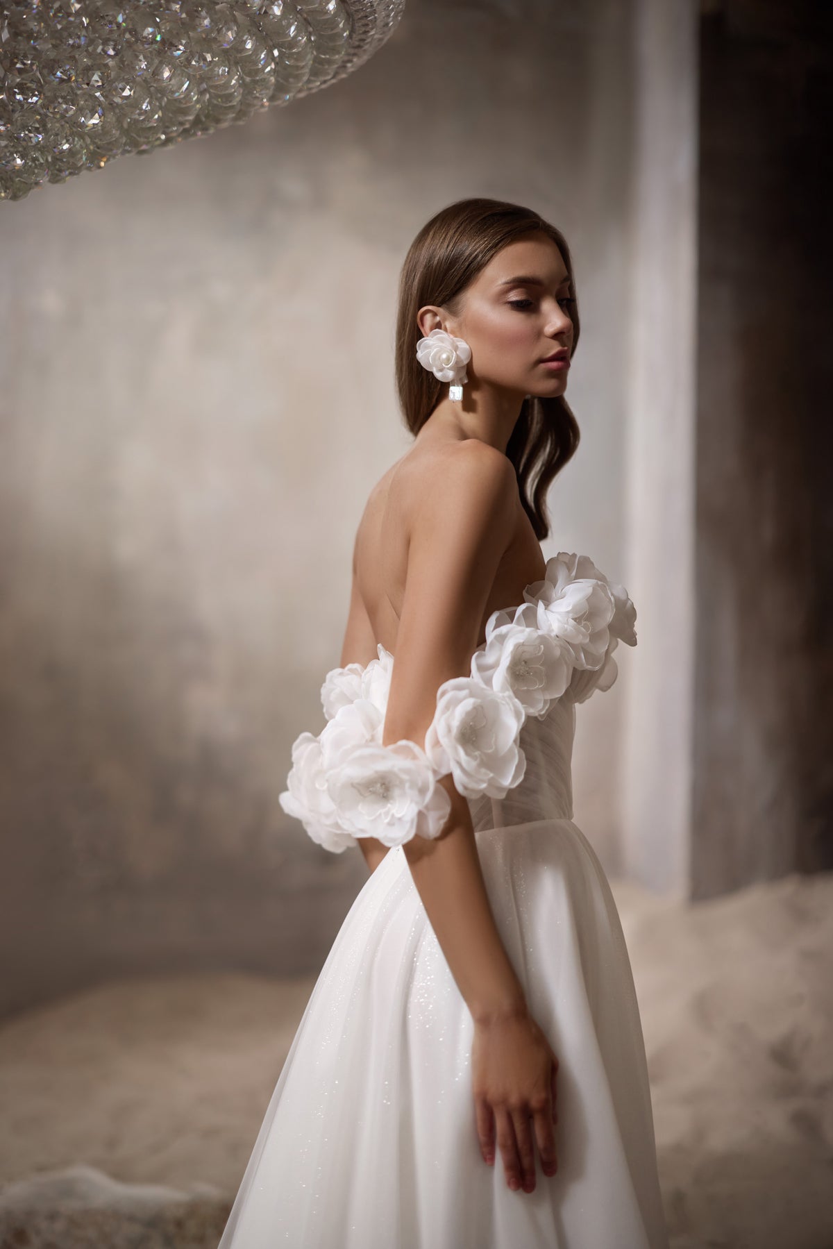 Open back and voluminous 3D floral off-the-shoulder sleeves on an ivory wedding dress