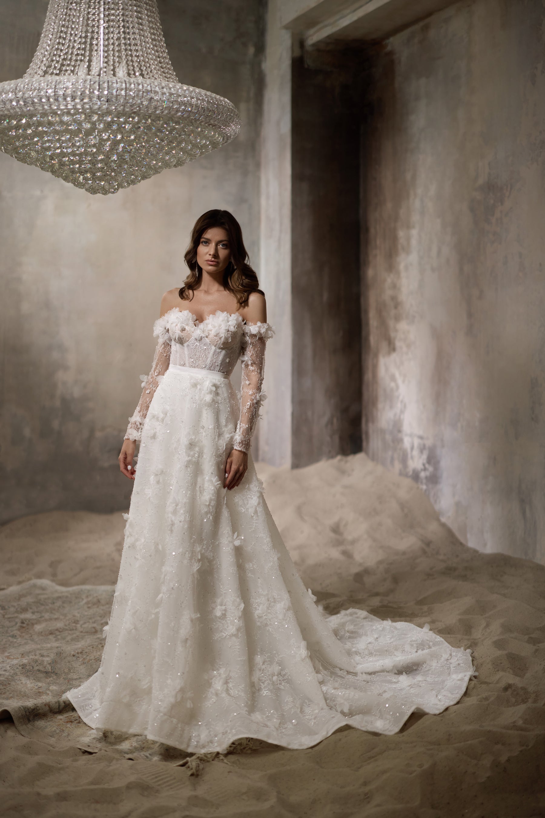 Ivory wedding dress with a beaded floral overskirt, off-the-shoulder sleeves, and long scalloped train