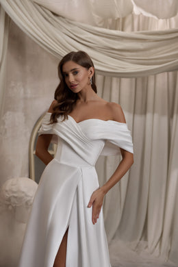 Ivory A-line wedding dress with a draped off-the-shoulder neckline and front slit