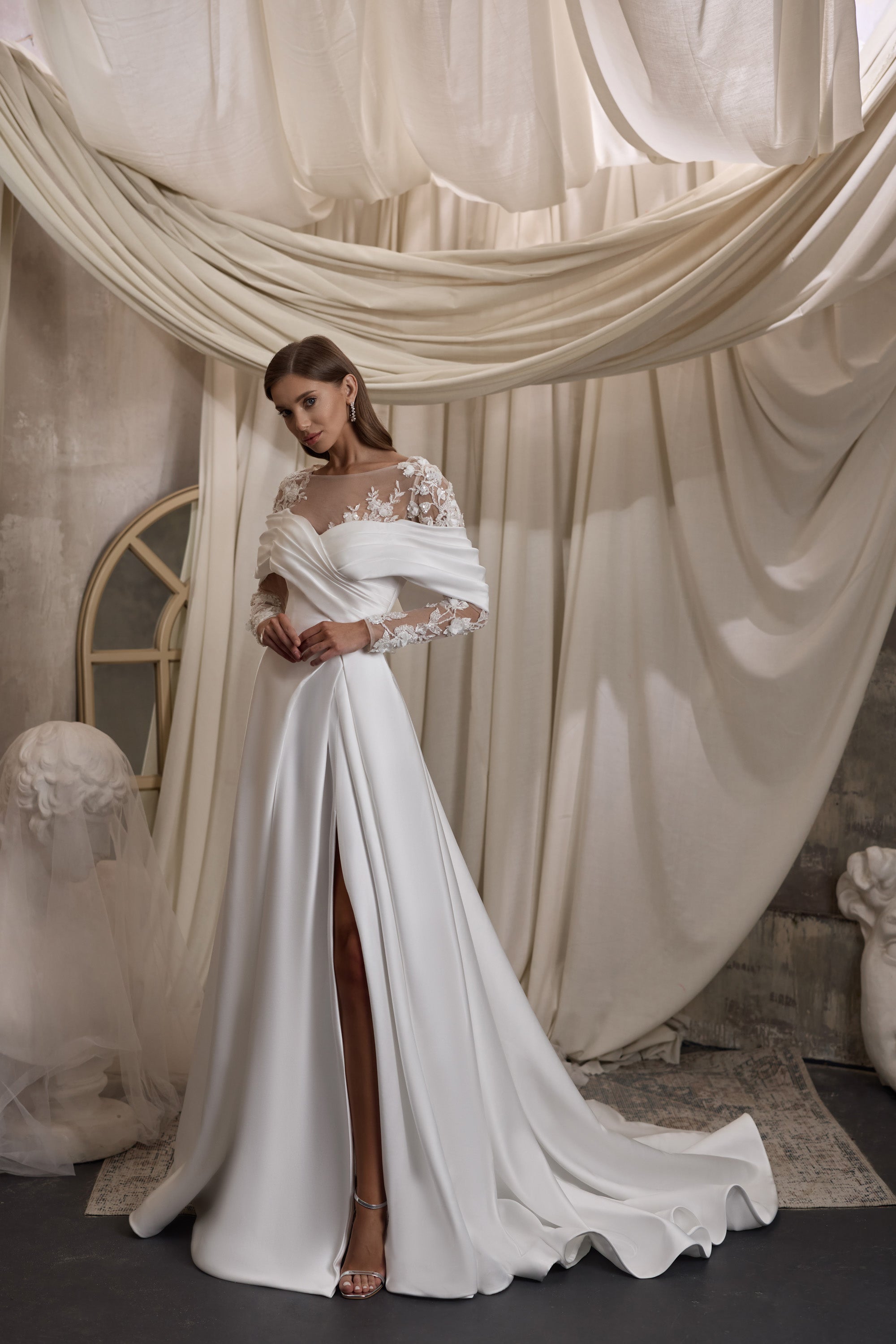 Ivory wedding dress with floral lace sleeves, an off-the-shoulder neckline, slit, and train