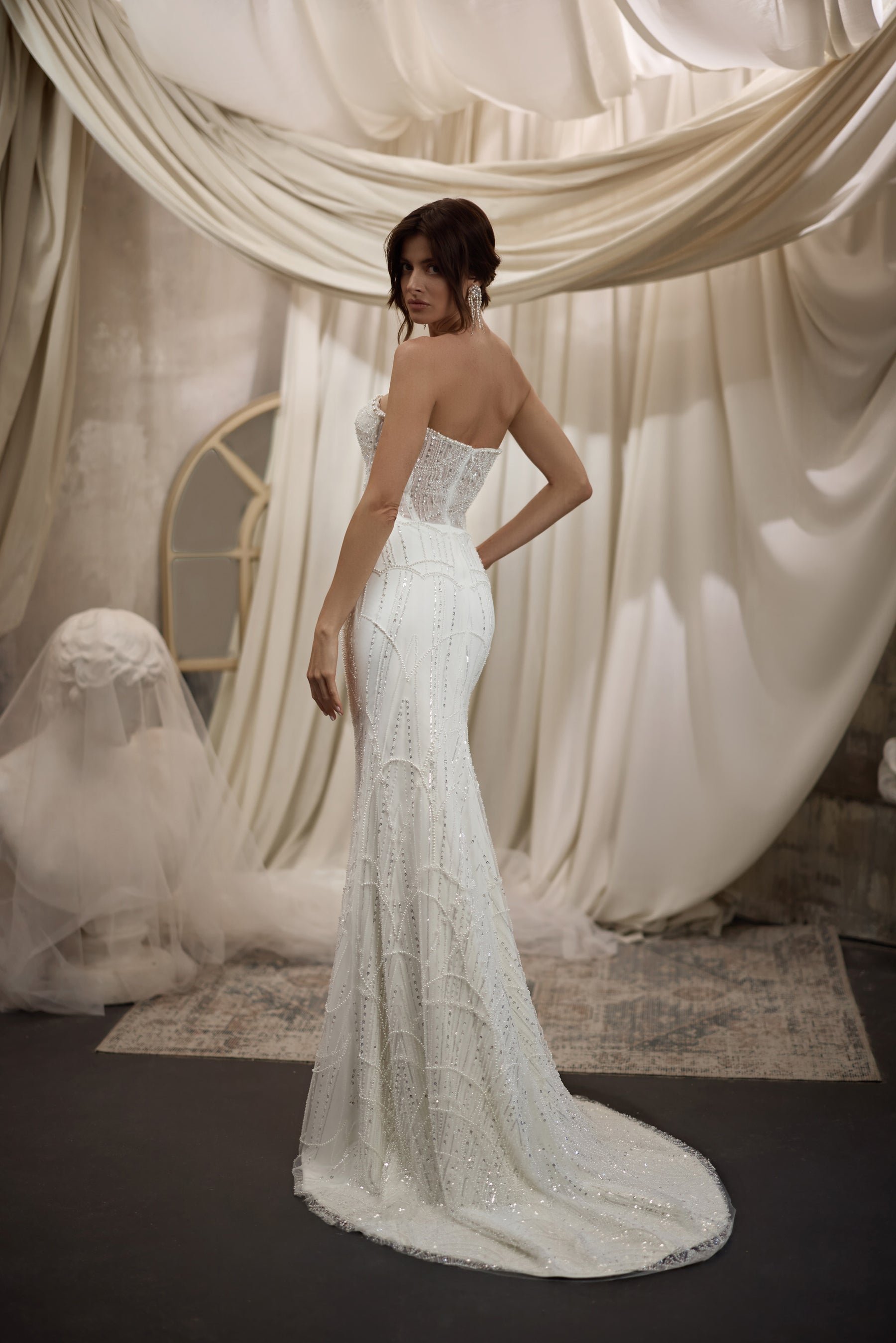 Fitted beaded sheath wedding dress with an open back and a long sweeping train