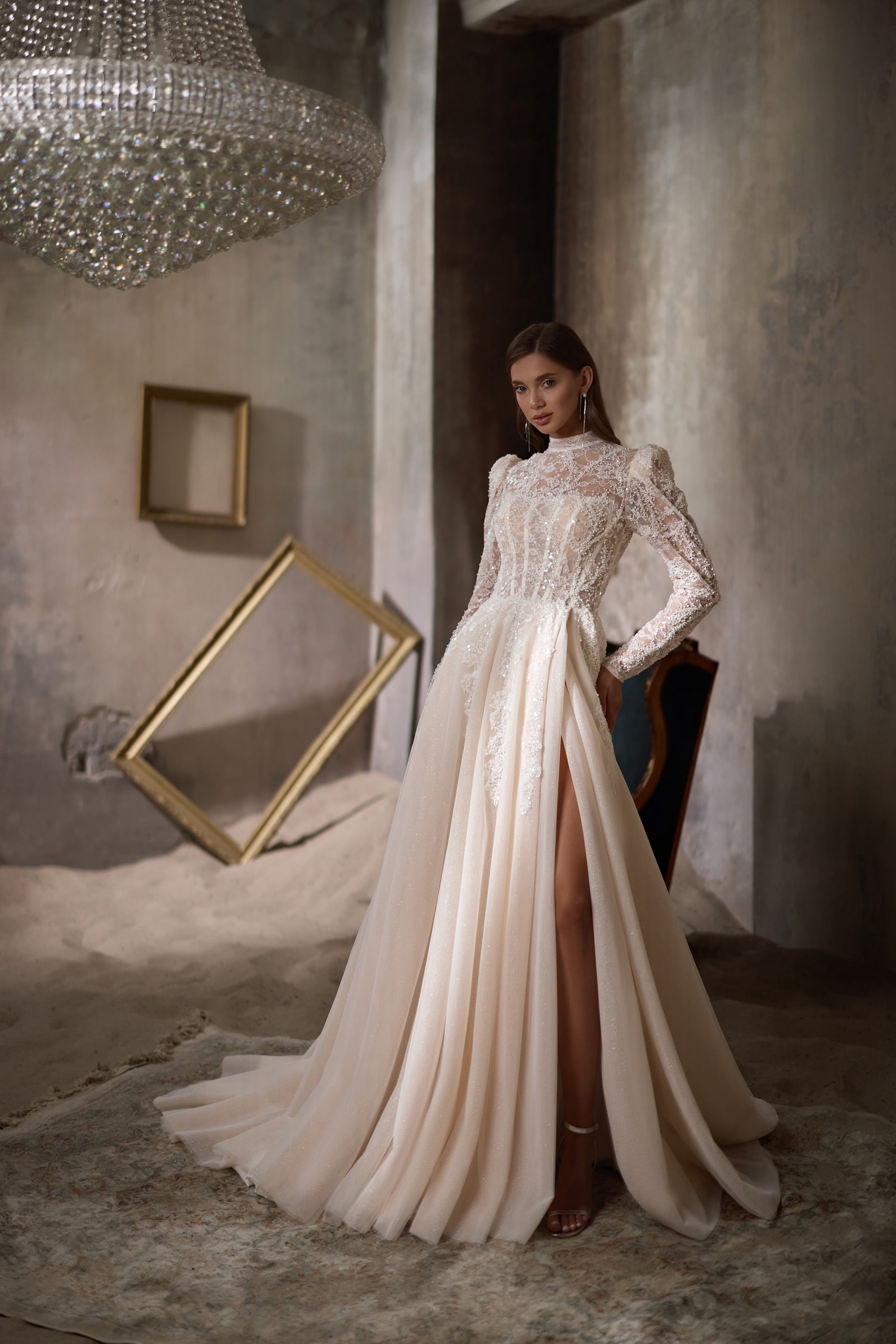 Ivory wedding dress with a high lace neckline, long sleeves, pleated A-line skirt, and thigh-high slit