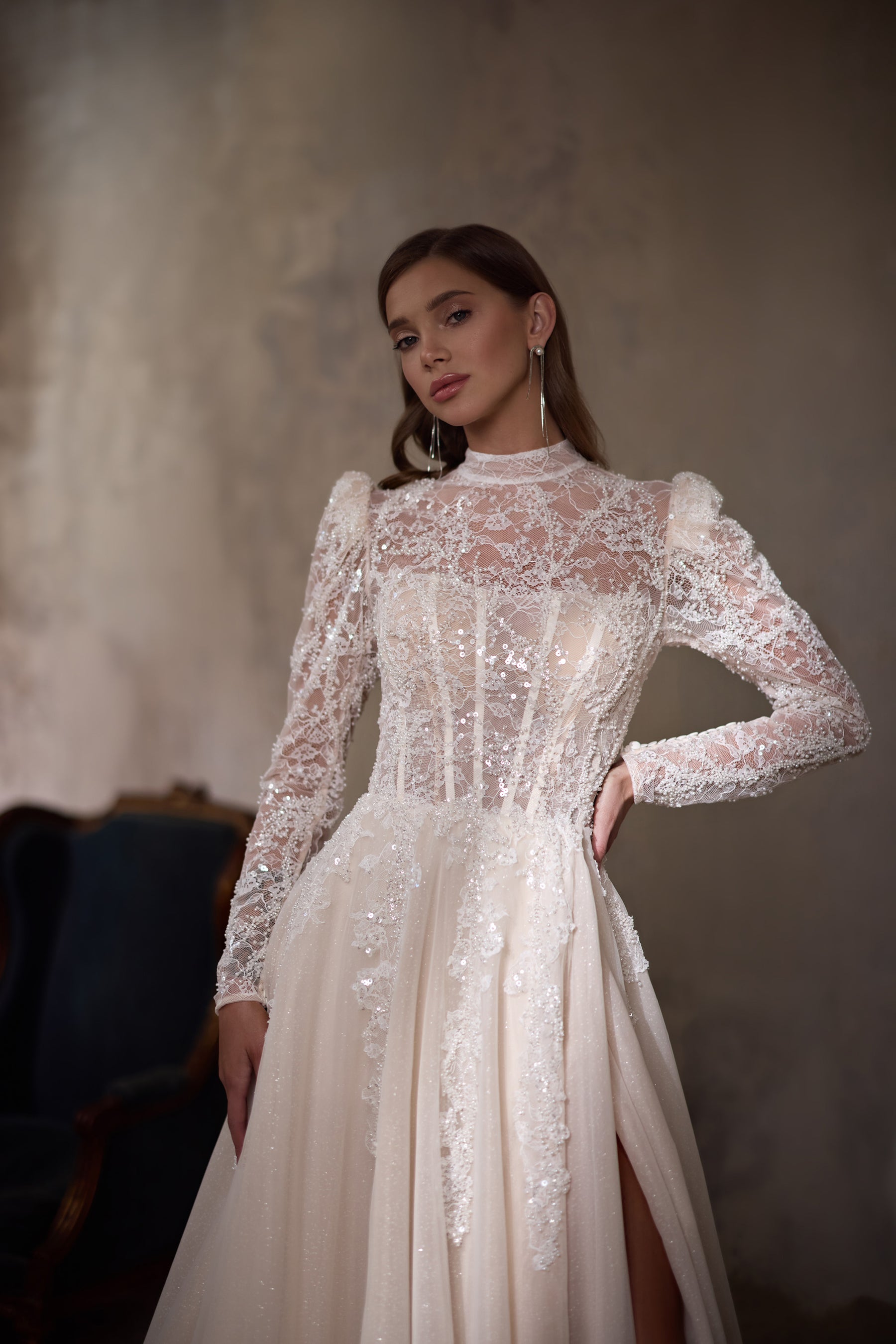 Ivory A-line wedding dress with a high lace neckline, long sleeves, fitted bodice, and front slit