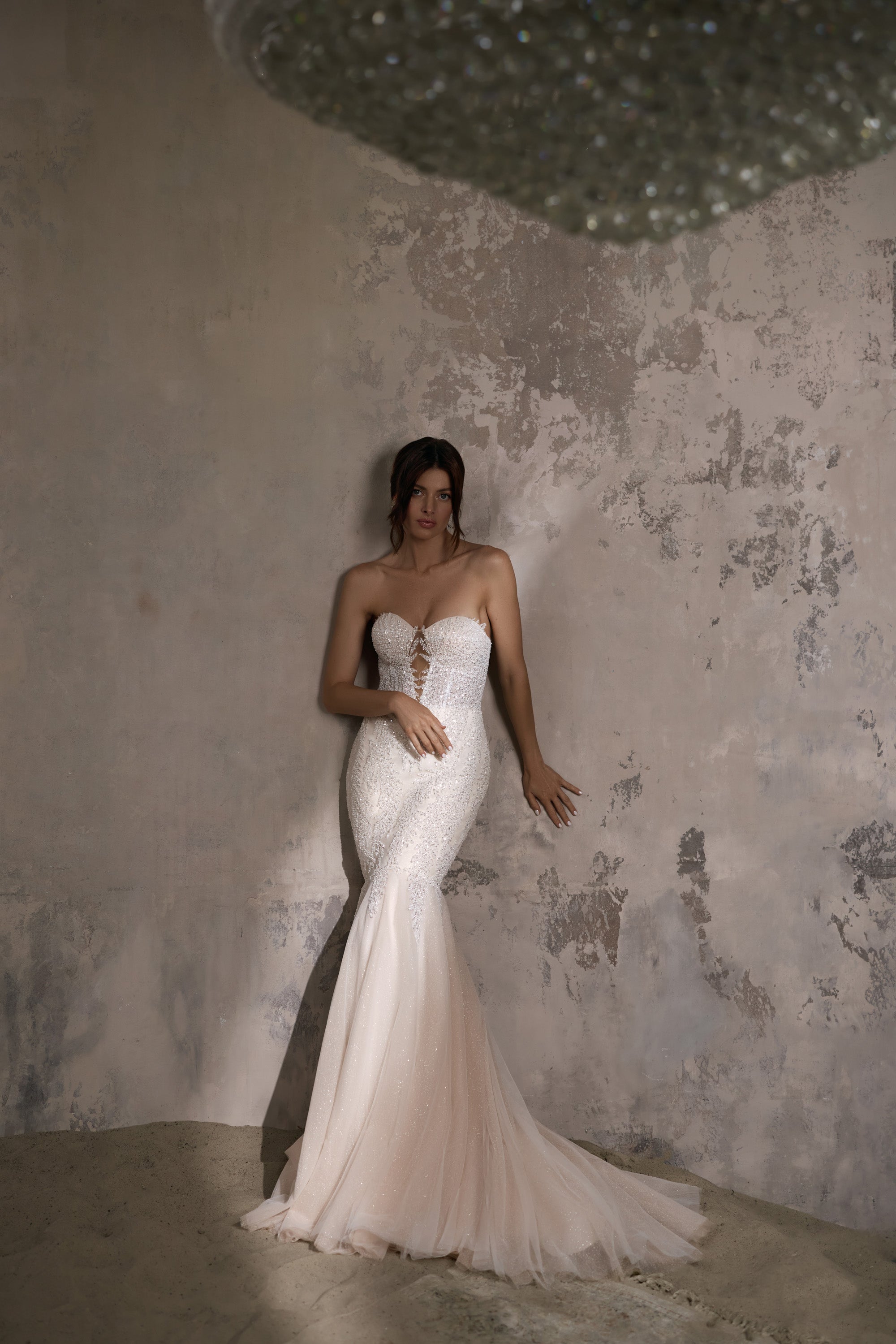 Ivory mermaid wedding dress with a strapless sweetheart neckline, beaded bodice, and flowing train