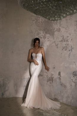 Ivory mermaid wedding dress with a strapless sweetheart neckline, beaded bodice, and flowing train
