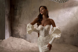Close-up of the beaded sweetheart bodice and detachable puff sleeves on an ivory wedding dress